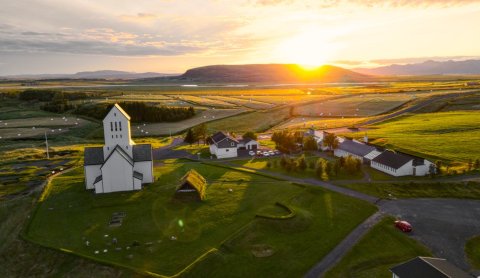 Skálholt with the Icelandic flag at sunset